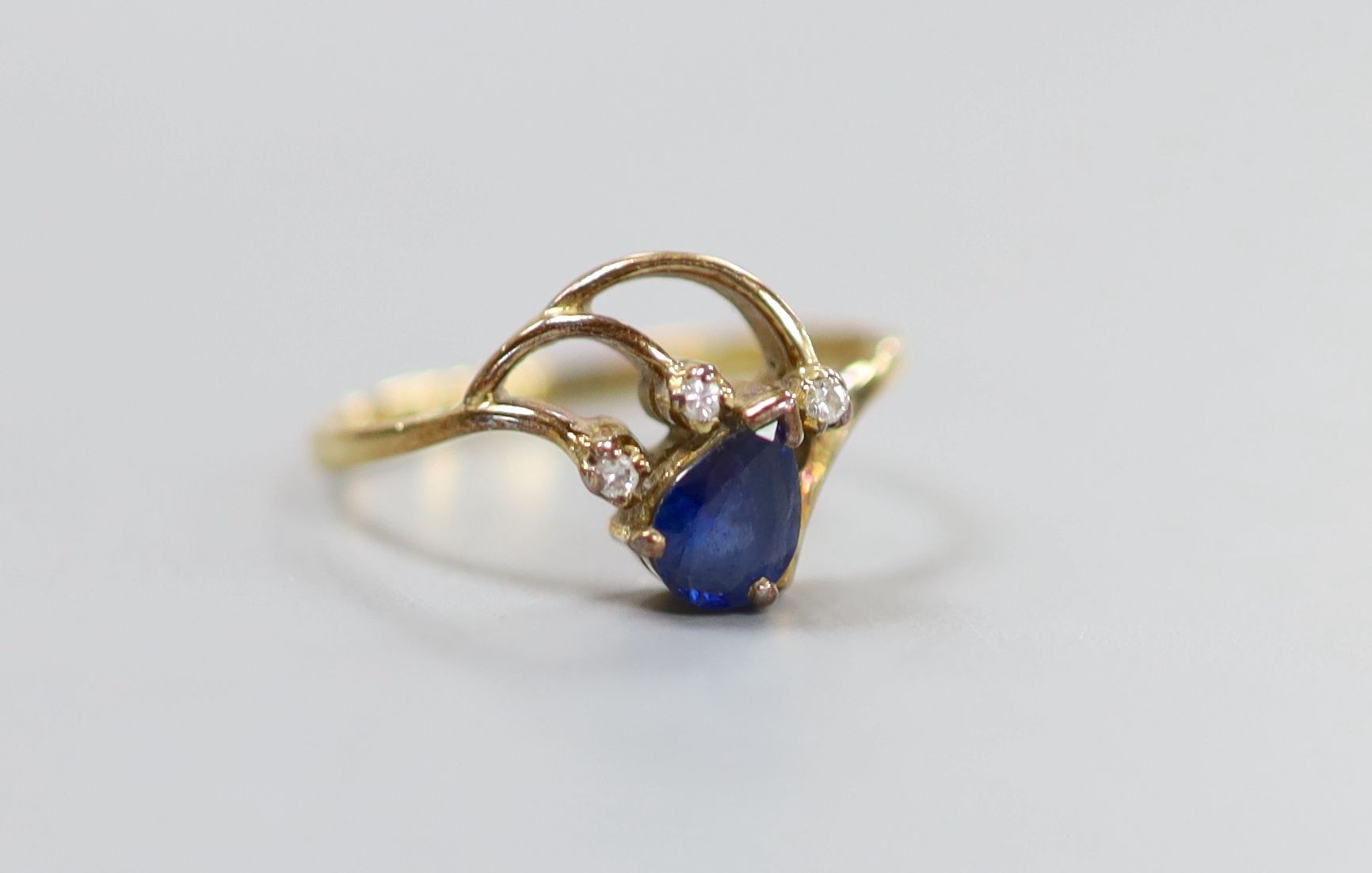 A yellow metal, pear cut sapphire and three stone diamond chip set ring, size J, gross 1.8 grams.